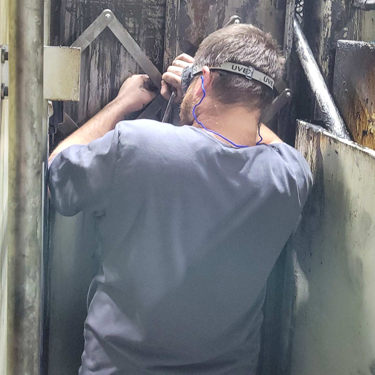 technician wearing safety glasses and working on a machine component
